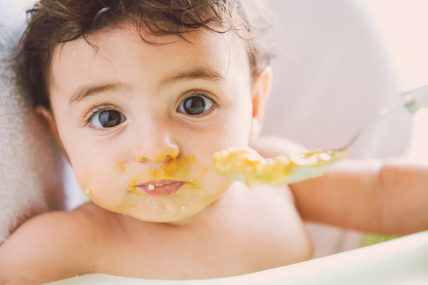Beautiful baby eating solids